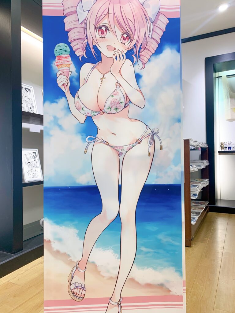 コミケ102新作のぴの水着タペストリーが飾られている『邪神ちゃん夏祭りミニPOP UP SHOP』